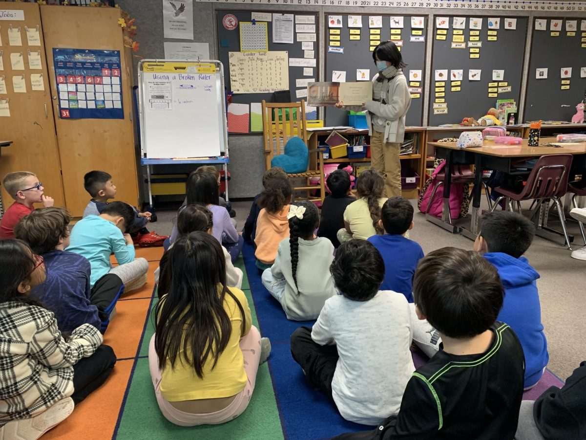 Rosie Dhan reading "the flying books of morris lessmore" to a second grade class